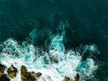 Kuş bakışı deniz kıyısı. Büyük dalgalar kayalıklara çarpıyor. Güneşli yaz arka planında güzel dalgalar deniz yüzeyinde inanılmaz deniz manzarası deniz manzarası manzarası