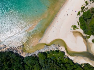 Kumlu sahile çarpan dalgaların hava görüntüsü, deniz yüzeyi okyanus dalgaları arka planı, plaj arka planı.