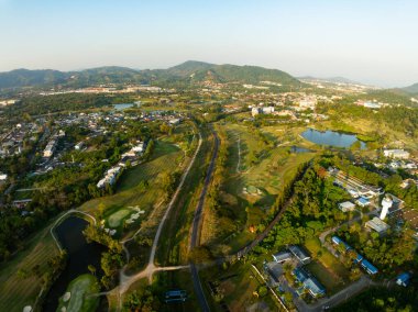 Gün batımında ya da günbatımında güzel yeşil golf sahasının hava görüntüsü, geniş açı üst görüş.