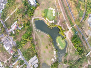 Gün batımında ya da günbatımında güzel yeşil golf sahasının hava görüntüsü, geniş açı üst görüş.
