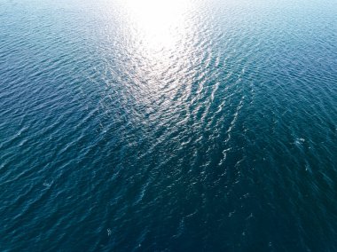 Aerial view of a blue sea surface water texture background,Sun reflections over ocean, Aerial flying drone view Waves water surface texture on sunny tropical ocean in Phuket island Thailand