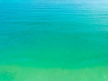 Deniz yüzeyinin inanılmaz arka planının havadan görünüşü, okyanus üzerindeki güneş yansımaları, havadan uçan dron görüntüsü Phuket Adası Tayland 'daki güneşli tropikal okyanusta su yüzeyi dokusunu dalgalandırıyor.