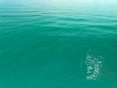 Deniz yüzeyinin inanılmaz arka planının havadan görünüşü, okyanus üzerindeki güneş yansımaları, havadan uçan dron görüntüsü Phuket Adası Tayland 'daki güneşli tropikal okyanusta su yüzeyi dokusunu dalgalandırıyor.