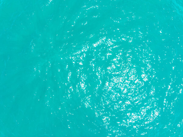 Aerial view of amazing sea surface water texture background,Sun reflections over ocean, Aerial flying drone view Waves water surface texture on sunny tropical ocean in Phuket island Thailand