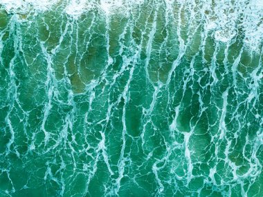 Okyanusta beyaz köpüklü turkuaz fırtınalı okyanus dalgaları, su sıçramalı köpüklü deniz suyu, üst görüntü dalgaları arka plan, dalgalı doğal arka plan fotoğraf deniz dokusu yumuşak odaklı