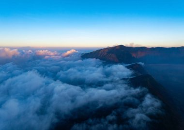 Endonezya 'da güneşin doğuşunda sisli güzel manzara dağları