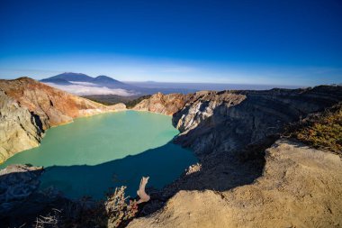 Gündoğumunda turkuaz sülfür gölü olan Kawah Ijen volkanı. Endonezya, Doğu Java 'da doğa manzarası. Doğal manzara arka planı