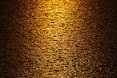 Dalgaların tam çerçeve arka planı deniz suyu dalgalanması ve altın güneş batımı ışığını yansıtması, deniz yüzeyinin soyut arkaplanı