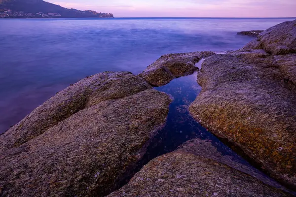 stock image Long exposure image of Dramatic sky seascape with rocks and waves crashing on seashore in sunset or sunrise scenery background