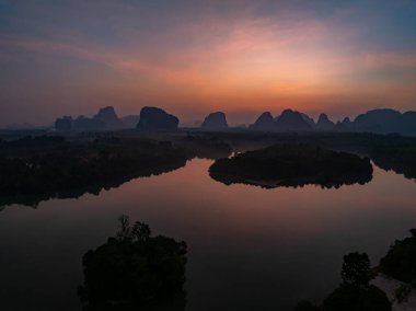 Gökyüzündeki görkemli bulutların hava manzarası günbatımı ya da deniz üzerindeki gün doğumunun tropikal denizdeki yansıması. Güzel manzara. Doğanın muhteşem ışığı.