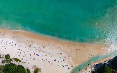 Phuket Tayland 'da yüksek mevsimde kumsalın ve güzel okyanusun tadını çıkaran insansız hava aracı.