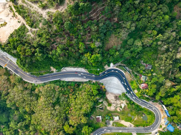 stock image Aerial view of mountain road in forest in summer season, Top view from drone of curve road, Landscape with curved roadway, Beautiful trees Travel asia Phuket Thailand