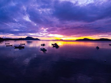 Gökyüzündeki görkemli bulutların hava manzarası günbatımı ya da deniz üzerindeki gün doğumunun tropikal denizdeki yansıması. Güzel manzara. Doğanın muhteşem ışığı.
