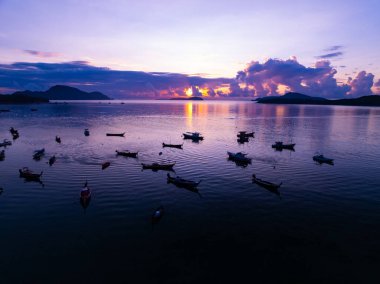 Gökyüzündeki görkemli bulutların hava manzarası günbatımı ya da deniz üzerindeki gün doğumunun tropikal denizdeki yansıması. Güzel manzara. Doğanın muhteşem ışığı.