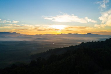 Güneşin doğuşu ya da batışı dağların tepelerinde sisle kaplı, hava manzaralı insansız hava aracı güzel renkli bir arka plan çekti.