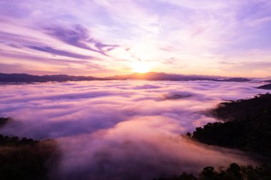 Güneşin doğuşu ya da batışı dağların tepelerinde sisle kaplı, hava manzaralı insansız hava aracı güzel renkli bir arka plan çekti.