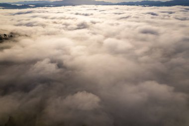 Güneşin doğuşu ya da batışı dağların tepelerinde sisle kaplı, hava manzaralı insansız hava aracı güzel renkli bir arka plan çekti.