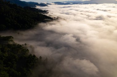 Güneşin doğuşu ya da batışı dağların tepelerinde sisle kaplı, hava manzaralı insansız hava aracı güzel renkli bir arka plan çekti.
