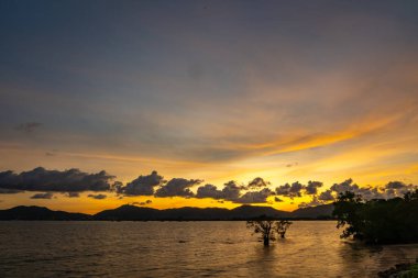 Gün batımında güzel bulutlar ya da deniz üzerinde gün doğumu, rengarenk manzara günbatımı gökyüzü, inanılmaz bulutlar muhteşem ışık arka plan