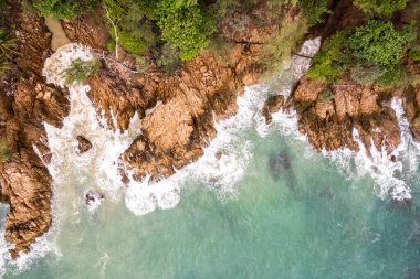 Kuş bakışı deniz kıyısı kayalıklara çarpan dalgalar güneşli yaz arka planında güzel dalgalar deniz yüzeyi inanılmaz deniz manzarası deniz manzarası