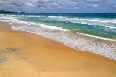 Kumlu sahile vuran dalgalar, yaz mevsiminde deniz manzaralı güzel dalgalar, inanılmaz plaj rengarenk su arka planı.