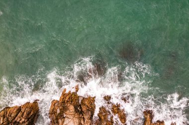 Kuş bakışı deniz kıyısı kayalıklara çarpan dalgalar güneşli yaz arka planında güzel dalgalar deniz yüzeyi inanılmaz deniz manzarası deniz manzarası