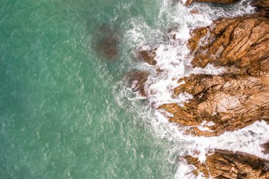 Kuş bakışı deniz kıyısı kayalıklara çarpan dalgalar güneşli yaz arka planında güzel dalgalar deniz yüzeyi inanılmaz deniz manzarası deniz manzarası