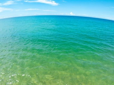 Mavi deniz yüzeyinin arka planının havadan görünüşü, suya yansıyan güneş ışığı, uçan dron görüntüsü Phuket Adası Tayland 'daki güneşli tropikal okyanusta su yüzeyi dokusu dalgaları.