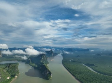 Dağların, deniz üzerinde bulutları olan tropikal yağmur ormanlarının hava görüntüsü.
