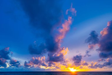 Gün batımında renkli bulutların manzarası ya da deniz üzerinde gün doğumu gökyüzü tropikal denizde yansıması, güzel deniz manzarası, doğanın inanılmaz ışığı doğa arka planı.