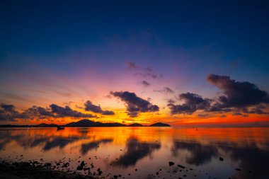Gün batımında renkli bulutların manzarası ya da deniz üzerinde gün doğumu gökyüzü tropikal denizde yansıması, güzel deniz manzarası, doğanın inanılmaz ışığı doğa arka planı.