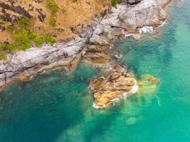 Püket Tayland 'daki güzel deniz kıyısı manzarası yaz mevsiminde kayalara çarpan muhteşem manzara dalgaları geniş açılı drone görüntüsü.