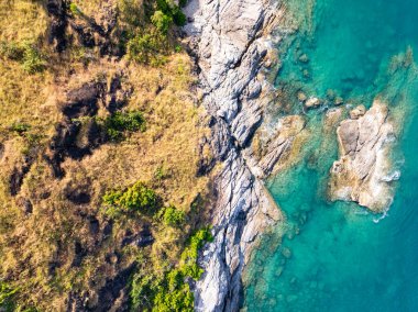 Püket Tayland 'daki güzel deniz kıyısı manzarası yaz mevsiminde kayalara çarpan muhteşem manzara dalgaları geniş açılı drone görüntüsü.