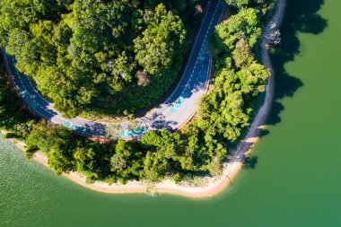 Yukarıdan aşağı yağmur ormanı baraj çevresinde asfalt yol ile Drone havadan görünümden