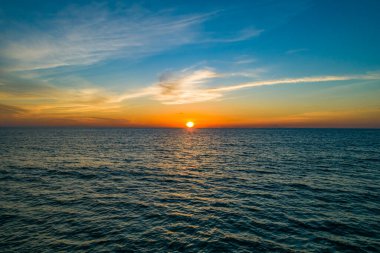 Hava manzaralı günbatımı gökyüzü, doğa güzel gün batımı ya da deniz yüzeyinde gün doğumu, okyanusta bulutlu ve dalgalı renkli günbatımı gökyüzü, geniş açılı deniz arka planı