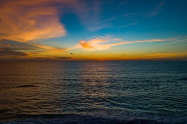 Hava manzaralı günbatımı gökyüzü, doğa güzel gün batımı ya da deniz yüzeyinde gün doğumu, okyanusta bulutlu ve dalgalı renkli günbatımı gökyüzü, geniş açılı deniz arka planı