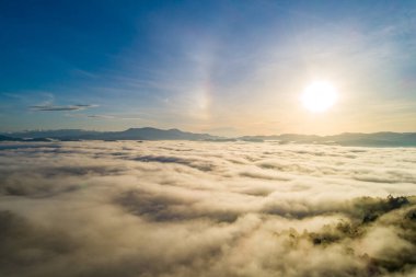 Güneşin dağların tepelerinde doğuşu sisle kaplı, hava manzaralı insansız hava aracı güzel renkli gökyüzü arka planı çekti.