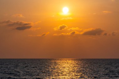 Doğa güzel gün batımı ya da deniz yüzeyinde gün doğumu, okyanusta bulutlu ve dalgalı renkli günbatımı, geniş açılı deniz arka planı