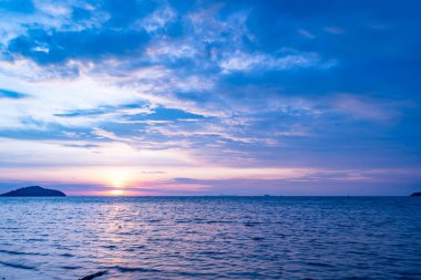 Doğa güzel gün batımı ya da deniz yüzeyinde gün doğumu, okyanusta bulutlu ve dalgalı renkli günbatımı, geniş açılı deniz arka planı