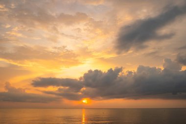 Doğa güzel gün batımı ya da deniz yüzeyinde gün doğumu, okyanusta bulutlu ve dalgalı renkli günbatımı, geniş açılı deniz arka planı