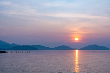 Doğa güzel gün batımı ya da deniz yüzeyinde gün doğumu, okyanusta bulutlu ve dalgalı renkli günbatımı, geniş açılı deniz arka planı