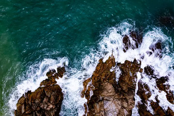 Üst görüntü dalgaları kayalara çarpıyor. Deniz manzarası, geniş açı, deniz doğası arka plan.
