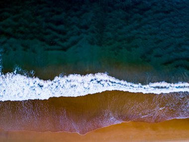 Yukarıdan aşağıya hava manzaralı dalgalar kumlu kıyılara çarpıyor yaz gününün arka planında karanlık deniz yüzeyi Phuket Tayland 'da deniz manzaralı dalgalar