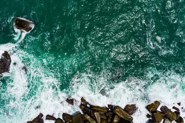 Deniz kıyısının yukarısı, kayalıklara vuran dalgalar güneşli yaz arkaplanındaki güzel deniz yüzeyi, Phuket Tayland 'daki inanılmaz deniz manzarası.