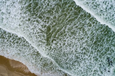 Hava manzaralı dalgalar kumlu kıyıya çarpar, yaz mevsimi arka planında deniz yüzeyi, deniz manzaralı dalga dokusu arkaplanı.