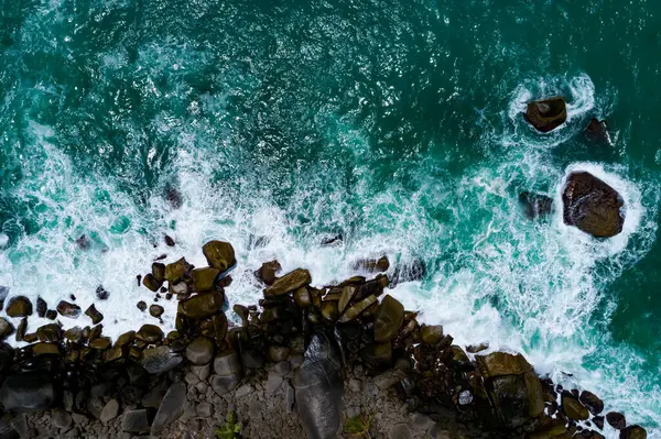 Deniz kıyısının yukarısı, kayalıklara vuran dalgalar güneşli yaz arkaplanındaki güzel deniz yüzeyi, Phuket Tayland 'daki inanılmaz deniz manzarası..