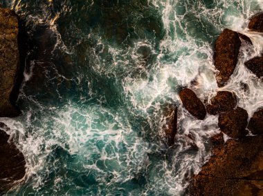 Üst görünüm deniz yüzeyi arka plan, kayaların üzerine düşen büyük dalgalar deniz manzarası arka plan