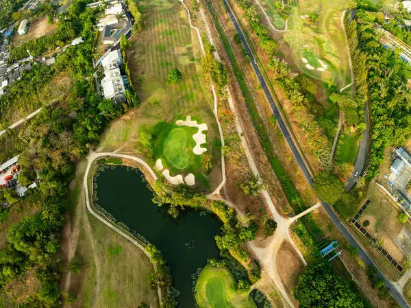 Yeşil golf sahasının havadan görüntüsü ve spor arka planı ve seyahat doğası arka planı için yukarıdan aşağıya yeşil görüntü.