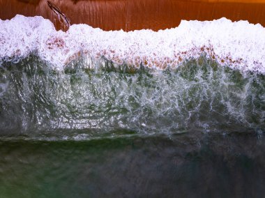 Kumlu sahile vuran dalgalarla en tepedeki sahile Yazın deniz manzaralı güzel dalgalar