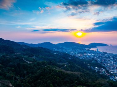 Patong Körfezi 'ndeki Phuket şehri Tayland' daki dağların üzerinde gün batımının güzel manzarası.